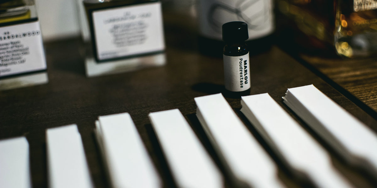 Smelling strips next to a Marlou Poudrextase sample vial