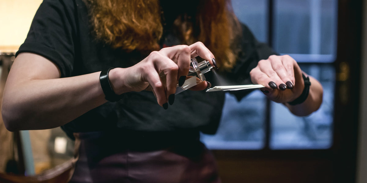 Spraying perfume onto a smelling strip at a Vetiveria event
