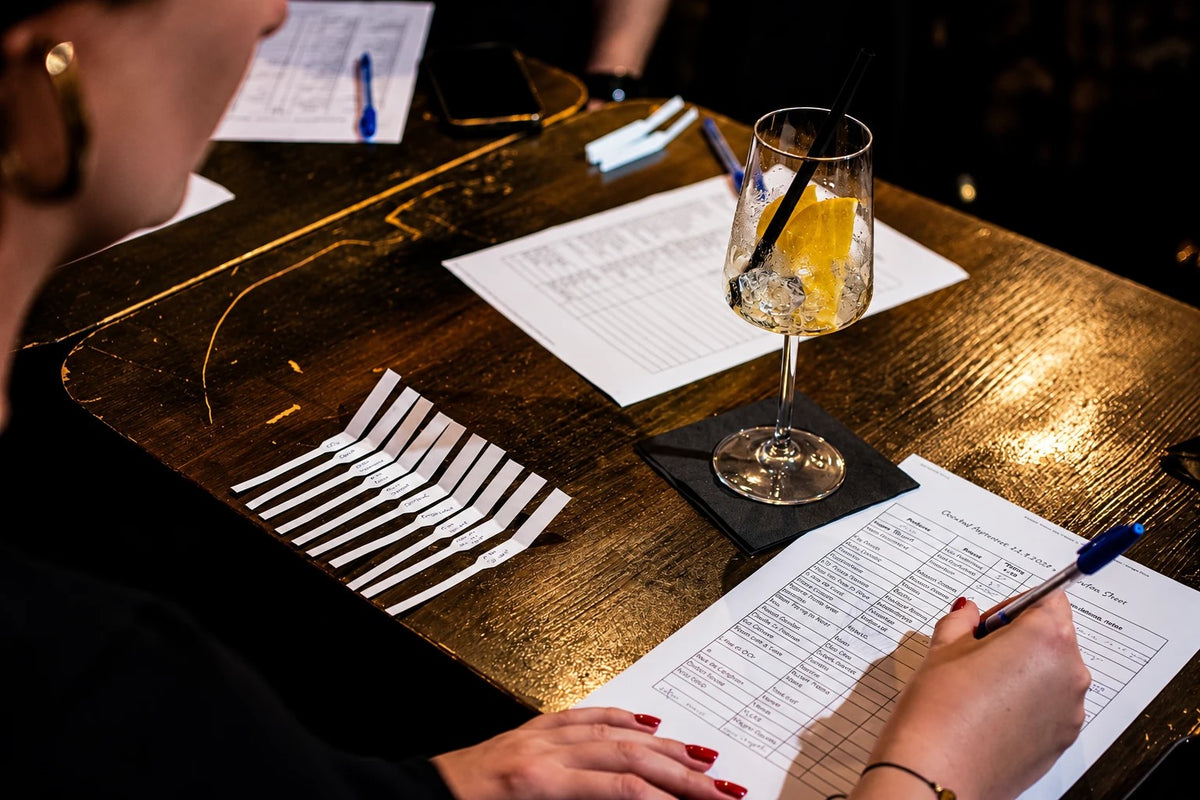 Guest taking notes next to labelled testing strips at a perfume workshop
